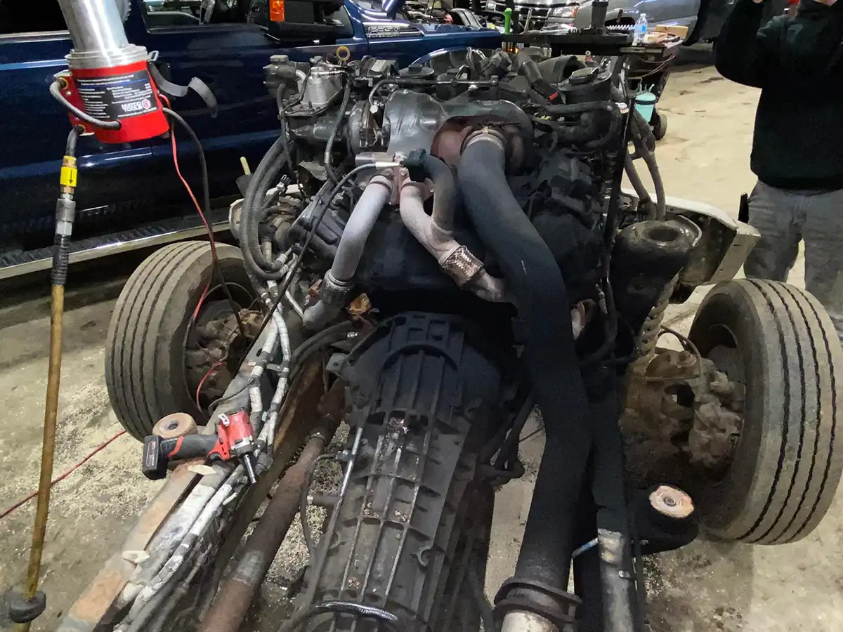 Commercial truck engine pulled from chassis for repair